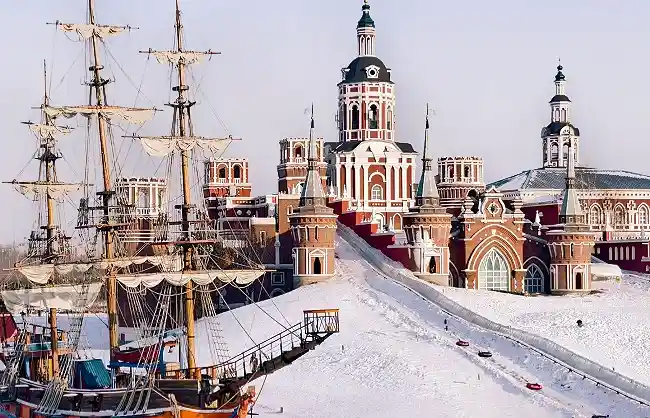 Snow-covered slopes with castle and ancient ship
