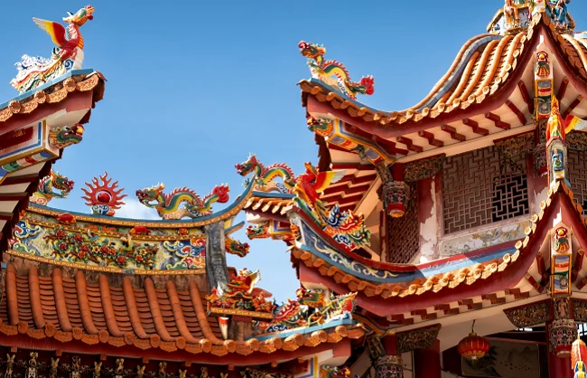 nanputuo-temple | China Xian Tour: Private & Tailor-Made China Tours Colorful Chinese temple rooftops with dragon statues and ornate beams against a clear blue sky.
