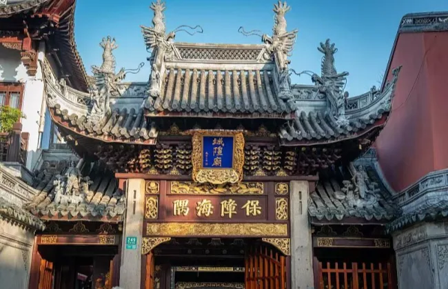 city-god-temple | China Xian Tour: Private & Tailor-Made China Tours Ornate traditional Chinese temple gate with dragon-topped roof, carved beams, and a gold plaque with Chinese characters.