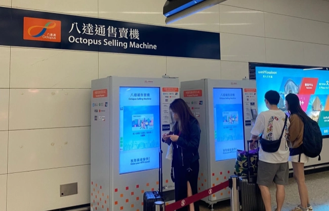 octopus-card-selling-machine | China Xian Tour: Private & Tailor-Made China Tours Row of Octopus Selling Machine kiosks at a station, with a blue sign reading'Octopus Selling Machine' in English and Chinese; two people using the touchscreen machines.